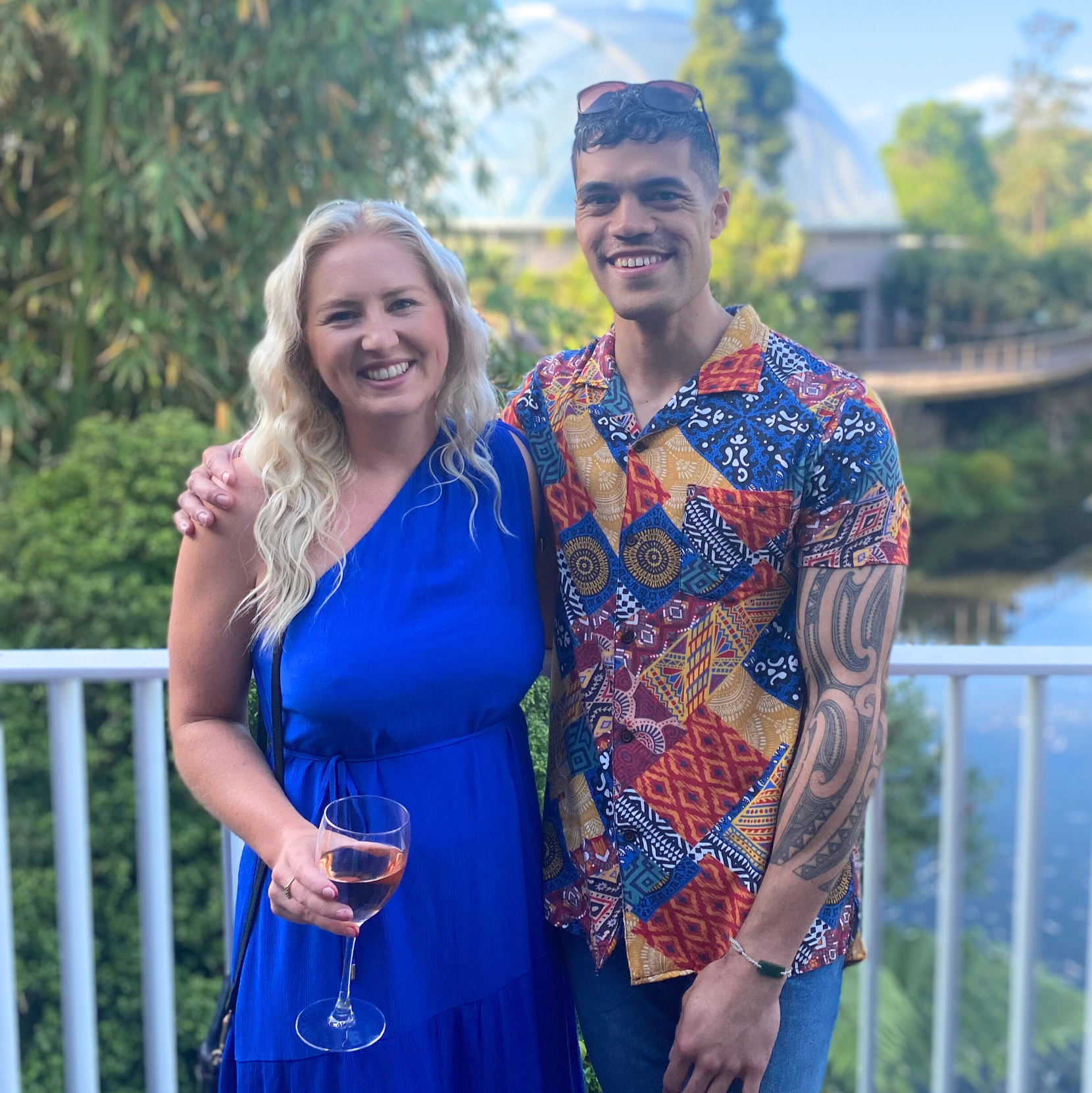 Two people standing together with a scenic background