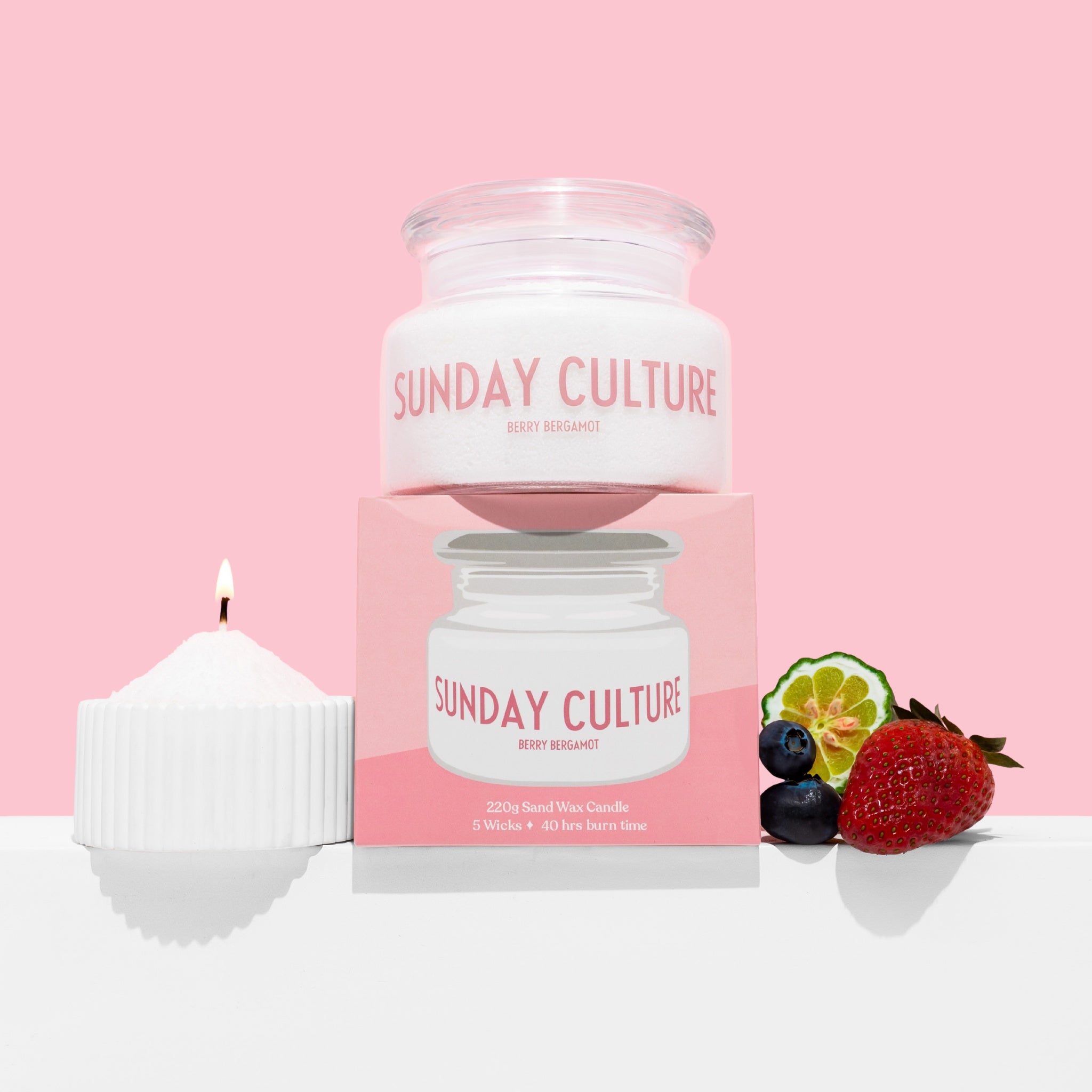 Sunday Culture candle and packaging with fruits on a pink background